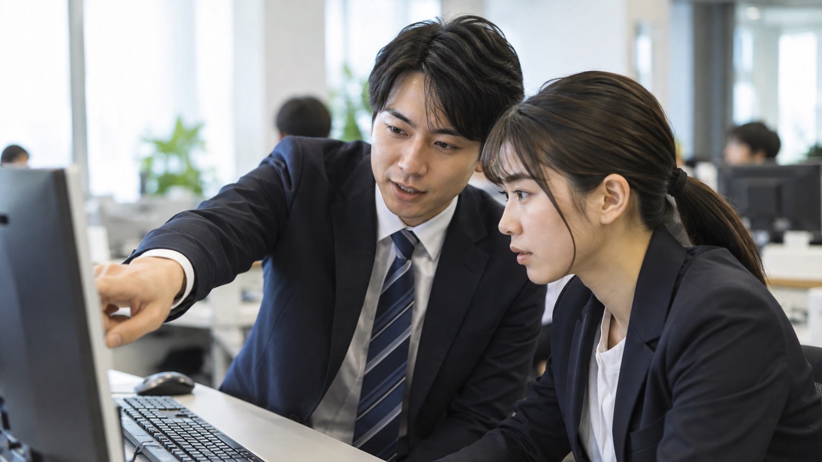 先輩から研修を受ける新入社員