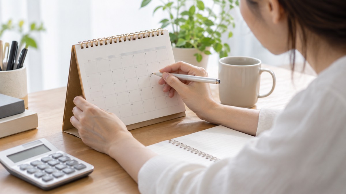 カレンダーと電卓で休日と給与を確認する手元