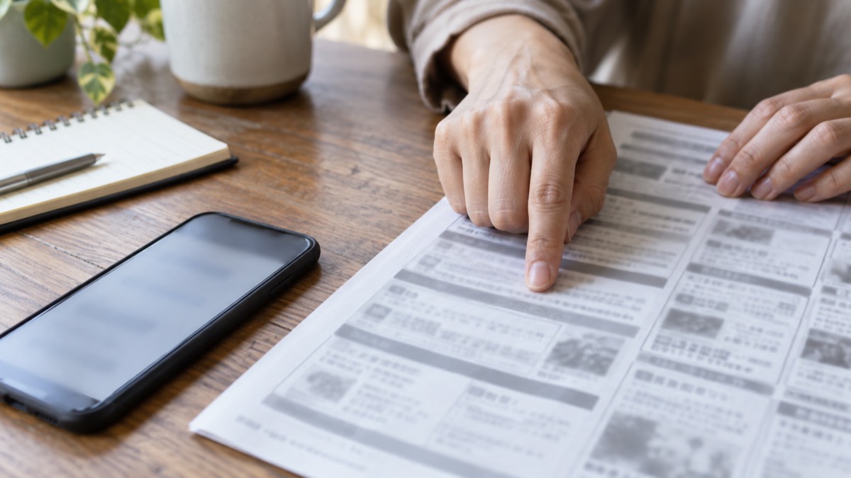 求人票の休日欄を指でなぞって確認する手元