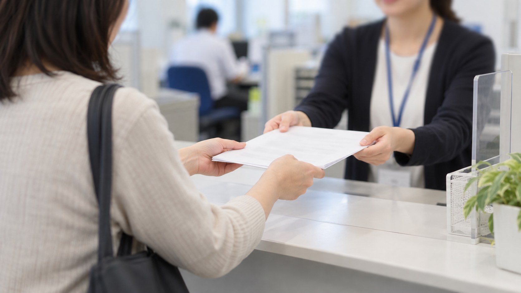 公的窓口のカウンターで書類を提出する場面