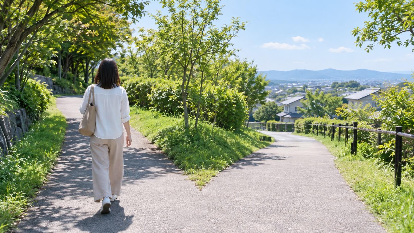分岐する道を歩き出す人物の後ろ姿