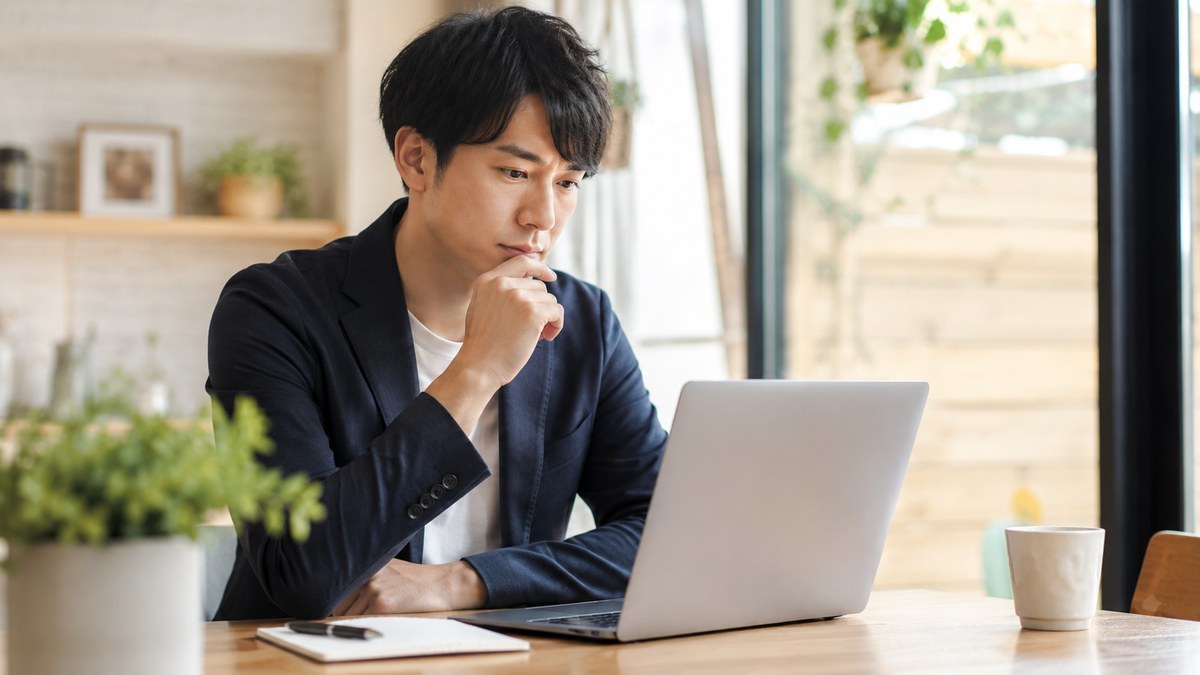 在職中の30代男性がノートPCで求人情報を確認する様子
