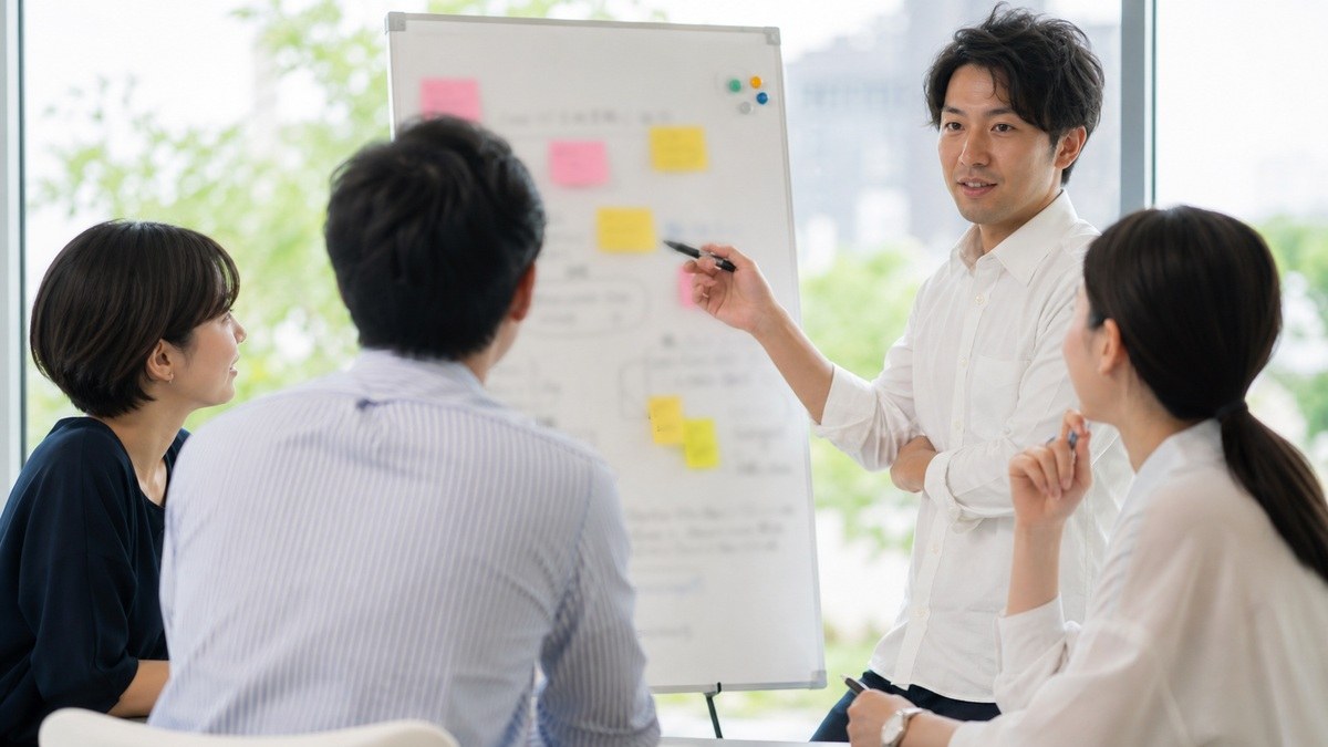 会議スペースで話し合う人たち 対人と判断が必要な仕事のイメージ