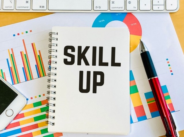 SKILL UPと書かれたノートと文具の写真|資格勉強やスキルアップのイメージ