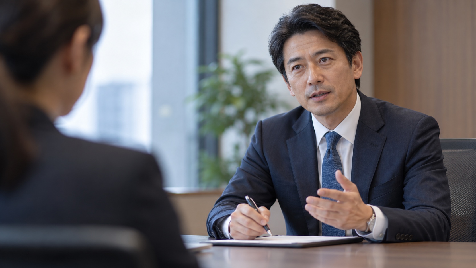 面接で落ち着いて質問する40代の日本人男性