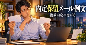 2通の内定通知を前に考える日本人男性のイメージ