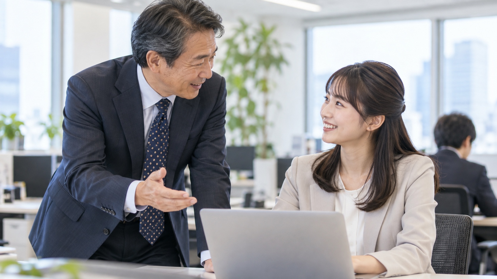 オフィスで話す50代と20代の日本人会社員
