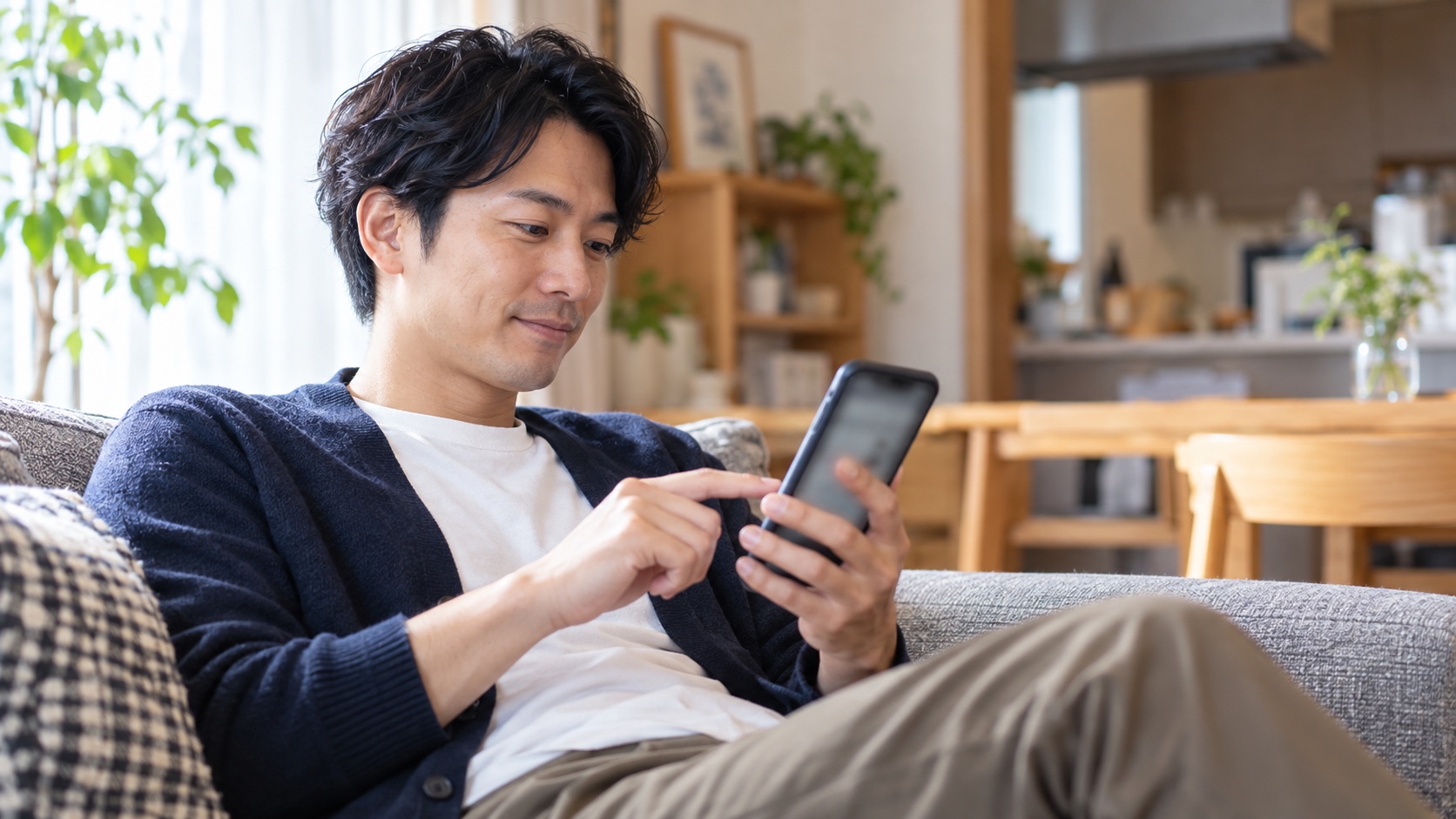 自宅でスマホのネットバンキングを確認する日本人の会社員
