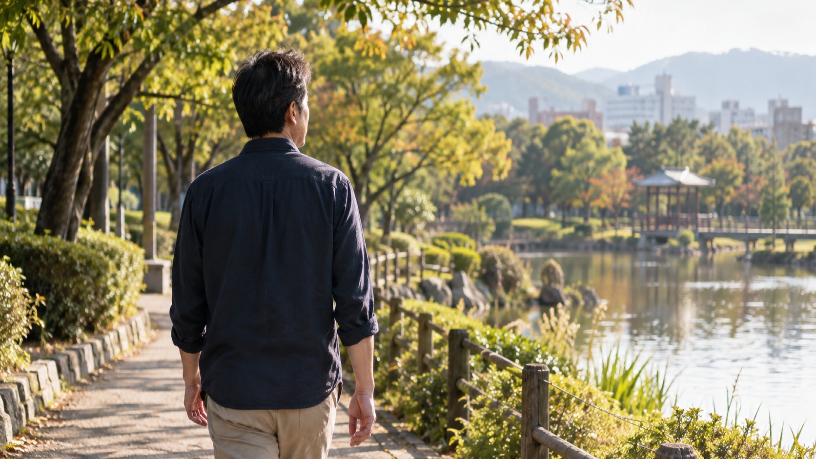 公園を落ち着いて歩く40代の日本人男性の後ろ姿