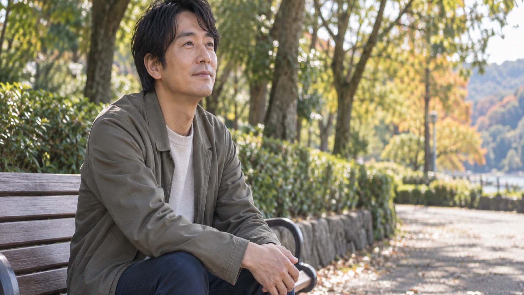 公園のベンチで落ち着いて座る40代の日本人男性